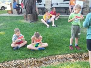 Táborozó gyerekek dinnyét esznek a Magyarkertben