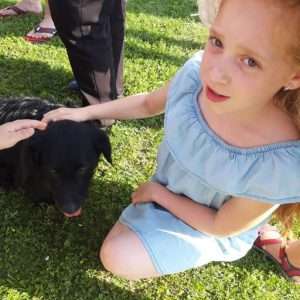 Egy kislány a Magyarkert kutyusát simogatja